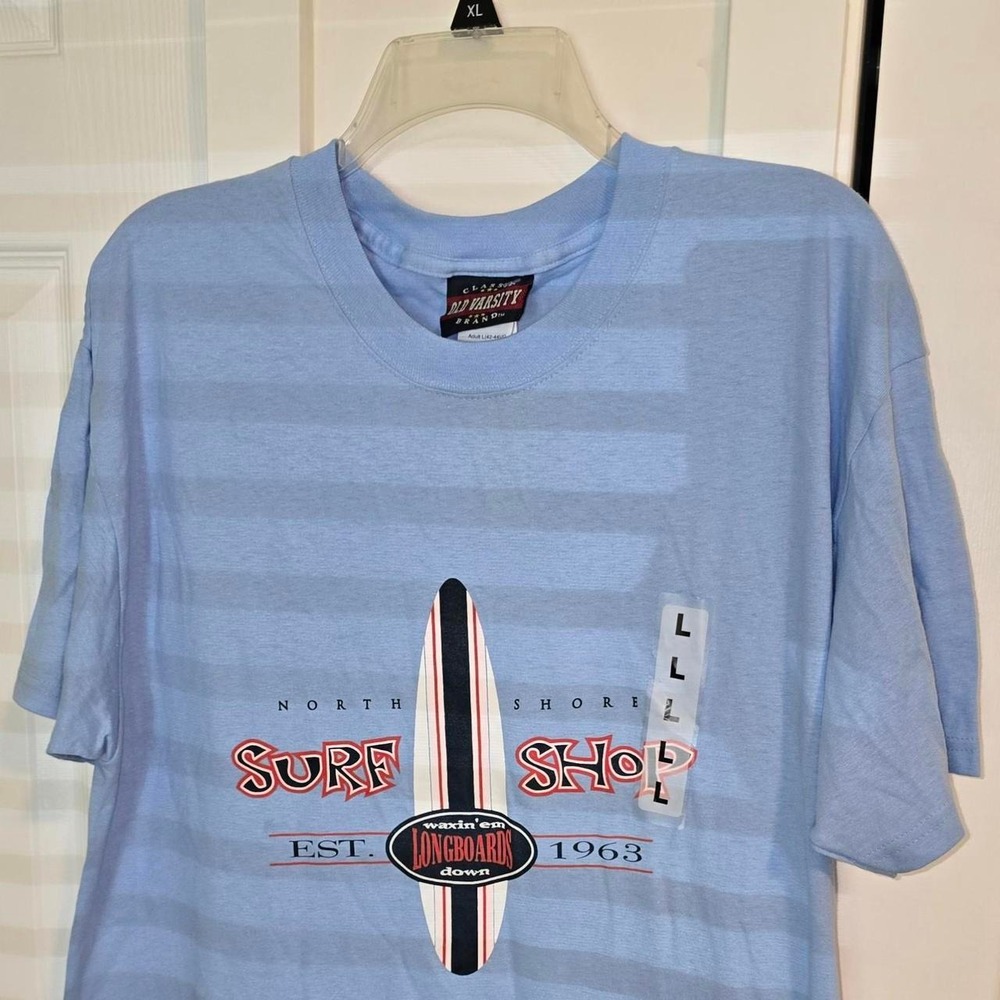 Blue Old Varsity Brand surf shirt with white and red surfboard graphic, size L